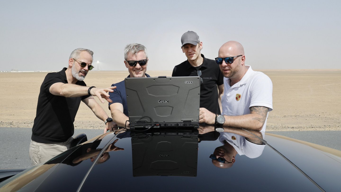 Frank Moser (Baureihenleiter 911 und 718, l.), Jörg Bergmeister (2.v.r.) und Team, Porsche 911 Prototyp, Dubai, Vereinigte Arabische Emirate, 2024, Porsche AG