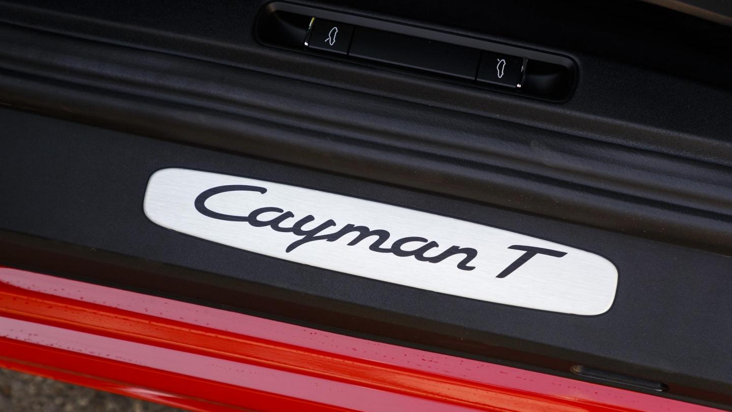 715 Cayman T - indischrot - Nahaufnahme - Einstiegsleiste Fahrertür - Logo Cayman T - Schweiz - 2019